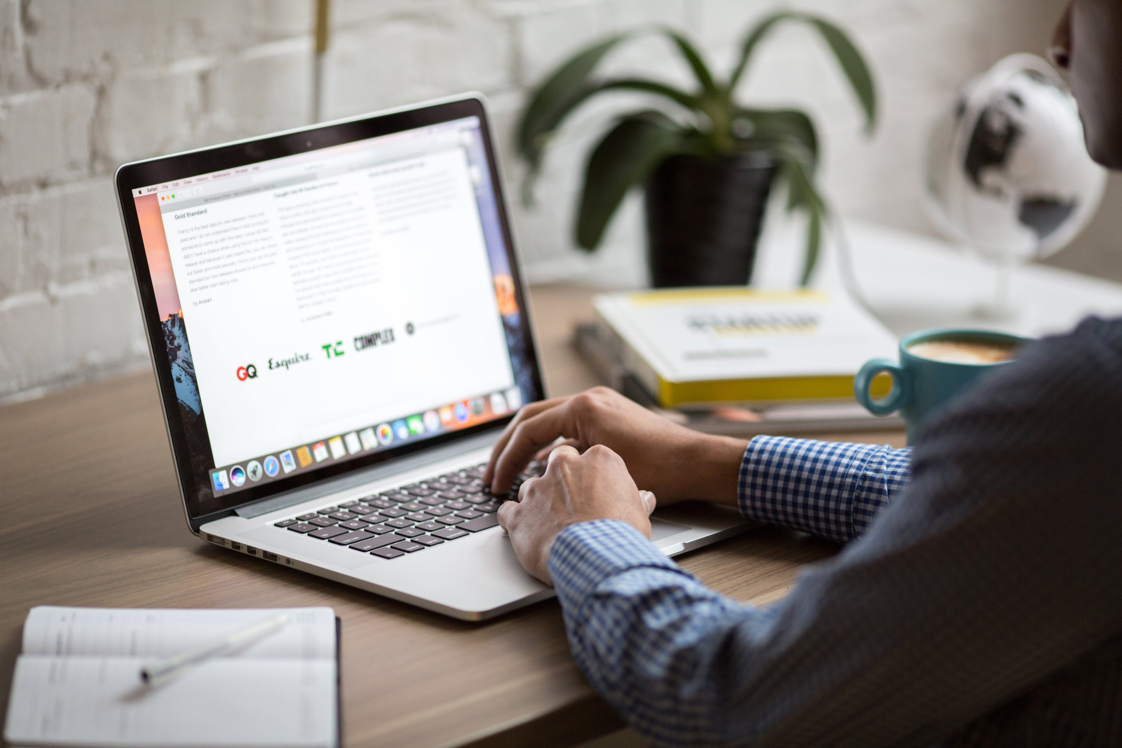 Photo shows a man sitting at a laptop learning and taking notes
