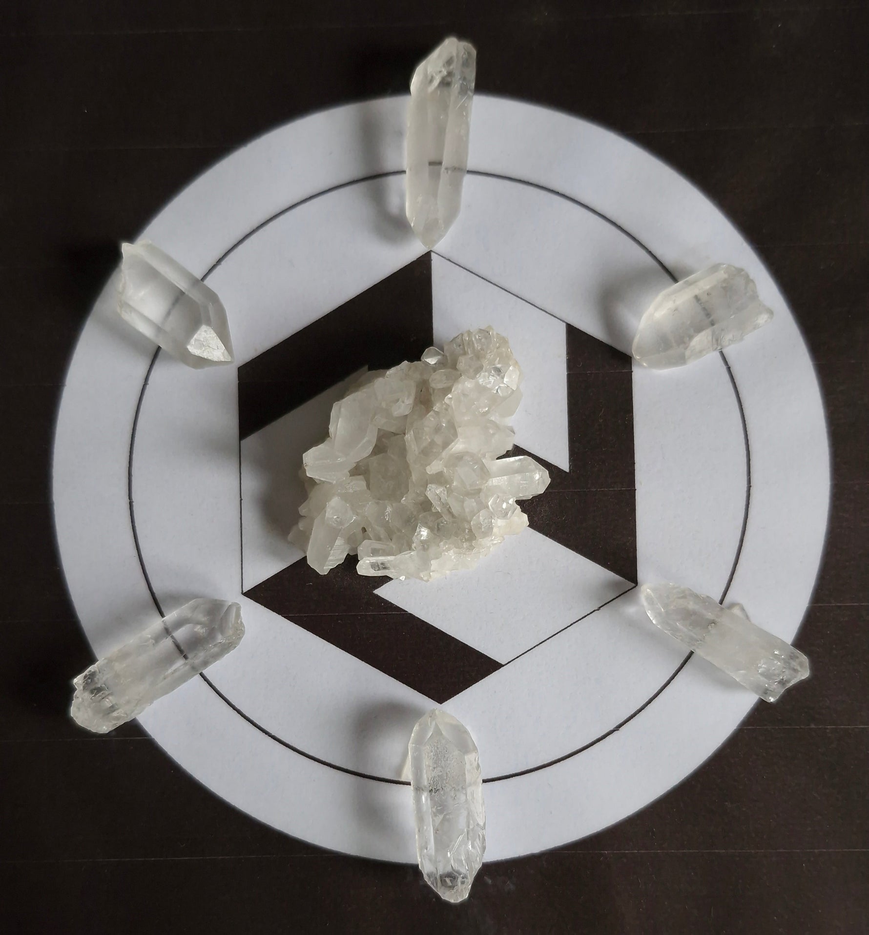 Distance Reiki crystal grid with clear quartz points and central cluster on Antahkarana symbol, used for remote energy healing sessions.

